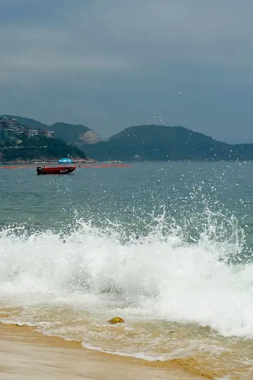 涌向岸边的潮水,溅起雪白细碎的浪花,引来游人驻足观看.