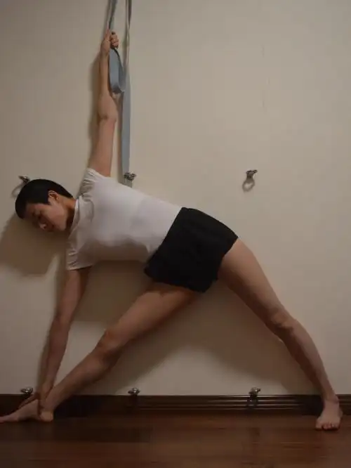 专注于大腿根的正确旋转,做瑜伽三角式.