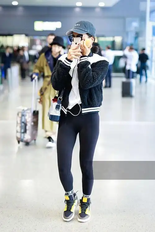 吉克隽逸穿黑白色外套配紧身裤秀纤细长腿 机场吃苹果十分接地气
