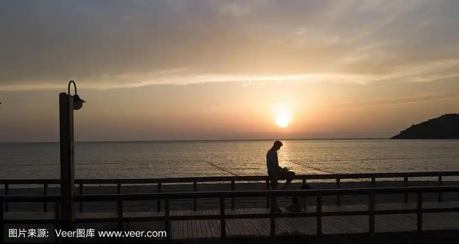 一个人的剪影在一个日落的背景海岸在夏天