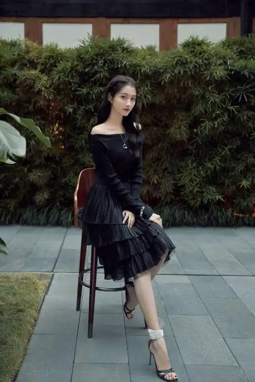 关晓彤身穿黑色露肩连衣裙,脚踩一字带高跟鞋,端庄优雅的坐姿,女人味