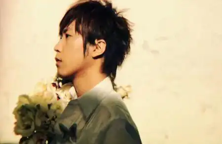 阿信的一张照片 侧脸 拿着一束花 浅黄色的背景色.求五迷给图谢谢谢谢