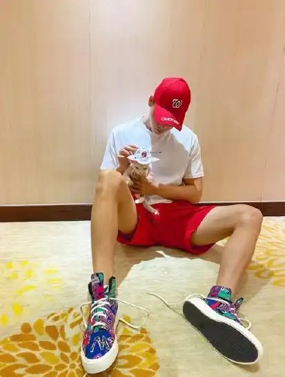戴着红色棒球帽的陈伟霆,穿着白色短袖搭配了红色五分裤,脚上一双