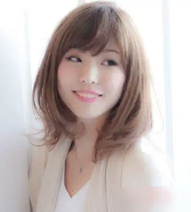 斜刘海内扣中长发发型,将额头上的发丝梳的倾斜一些,内扣头发的发尾