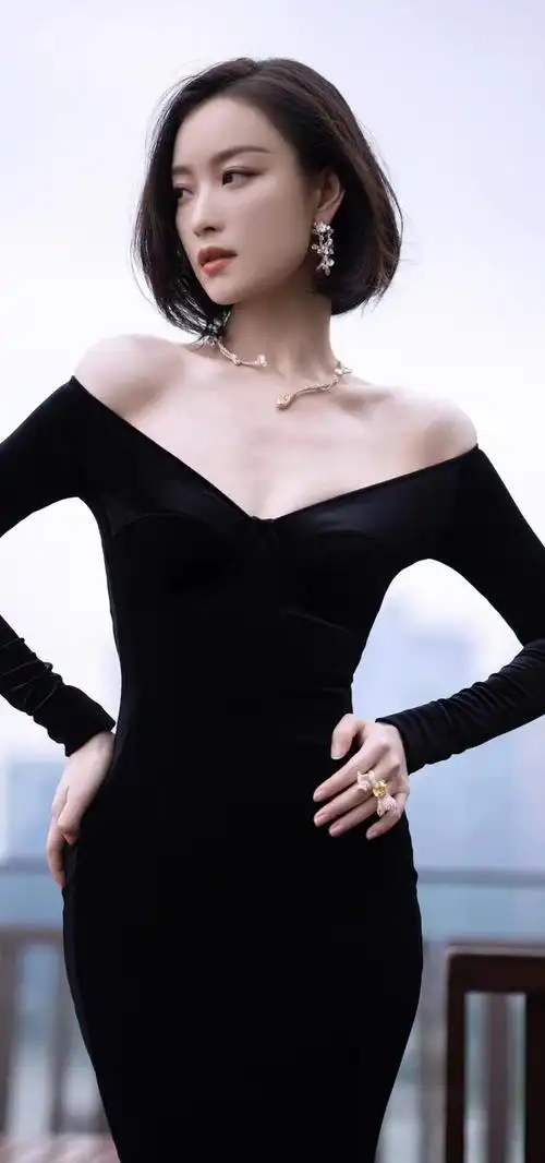 简直就是人生赢家了吧,她穿着一件黑色的裙子,双手撑在腰上,头发半遮