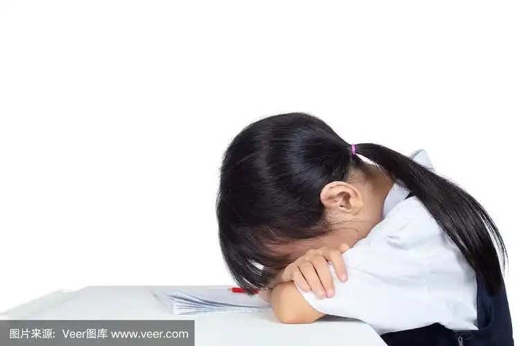 穿着校服的亚洲华人小女孩睡在桌子上