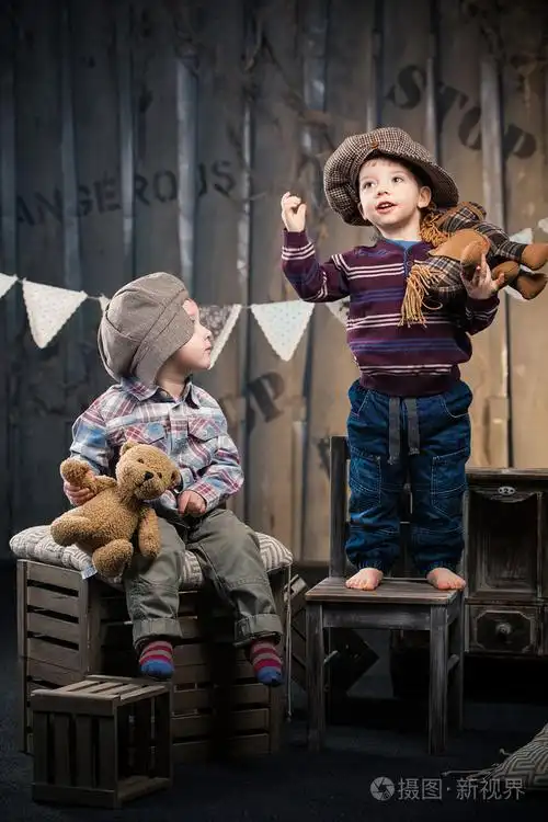 两个小男孩在帽坐在工作室中的框上大约如此