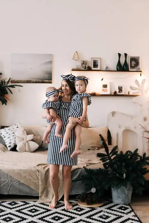 年轻美丽的母亲与两个女儿在圣诞节装饰工作室.圣诞快乐和新年概念