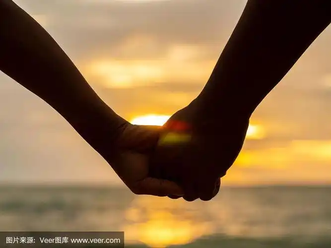 夫妇牵手在美丽的日落背景在海滩.爱与家庭观念.