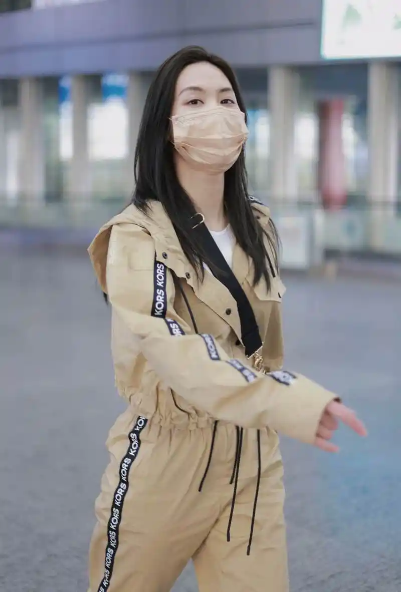 王霏霏最新机场私服,身穿卡其色连帽印花短外套和加工裤装套装,搭配