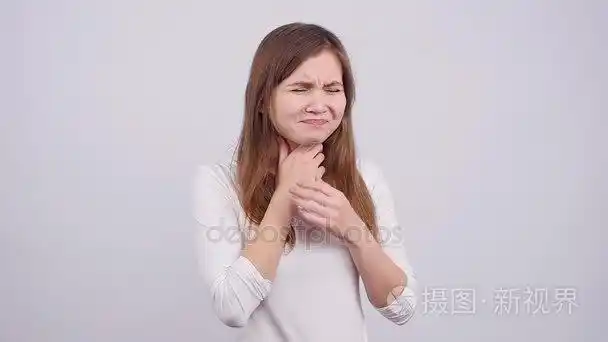 一个年轻的女人在灰色背景下喉咙痛短视频