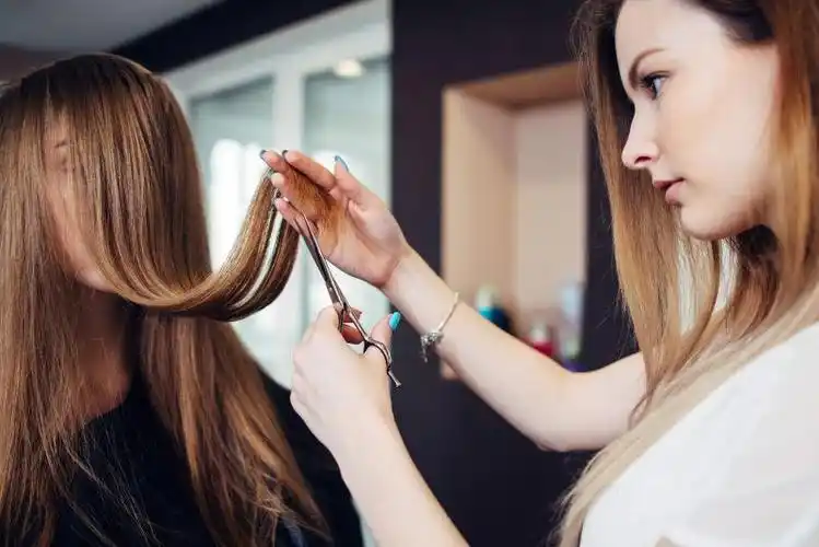 美发师在美容院修剪女顾客的长头发