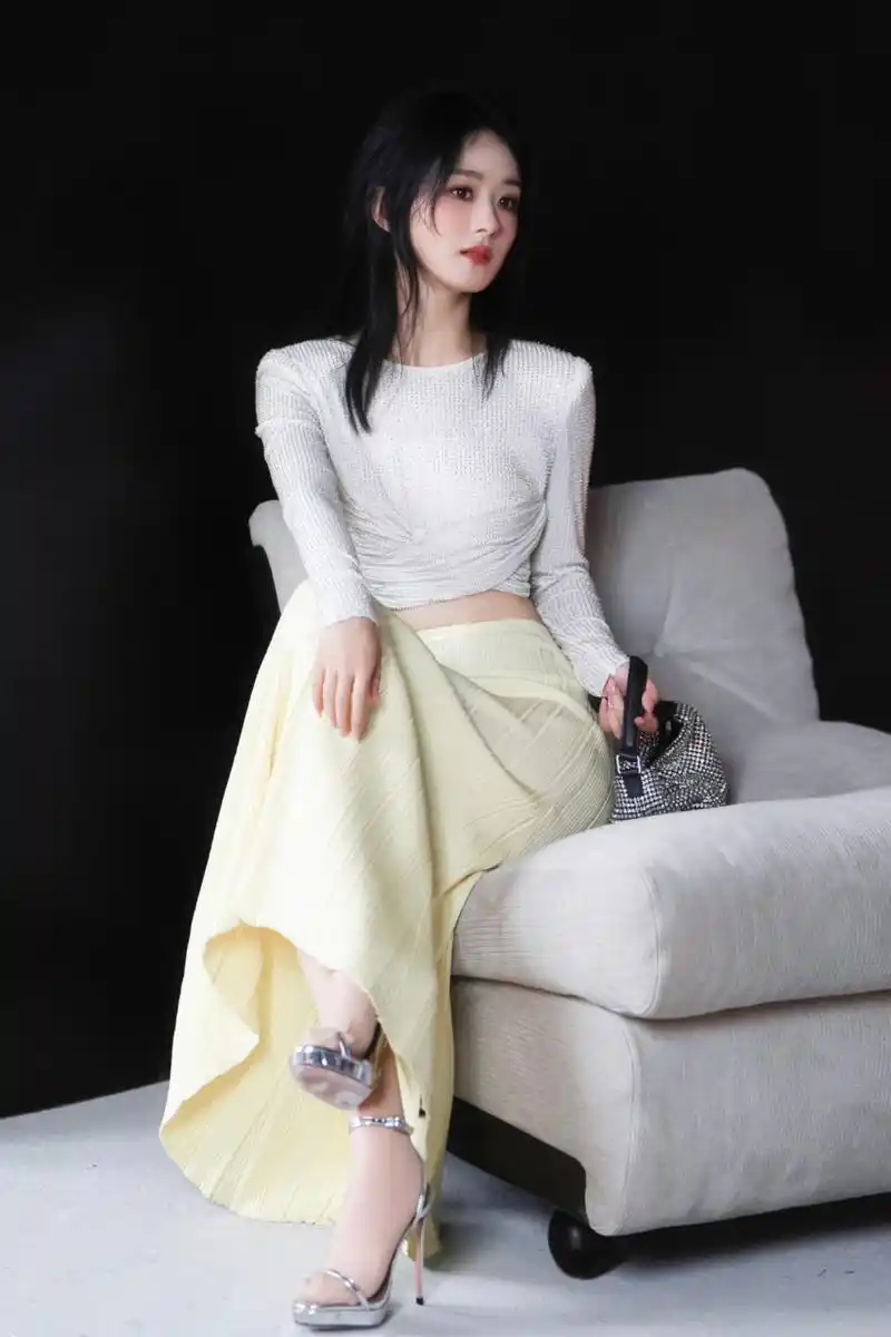 赵丽颖身穿白色烫钻扭结上衣搭配黄色半身裙,甜美可爱,妆容精致,大秀