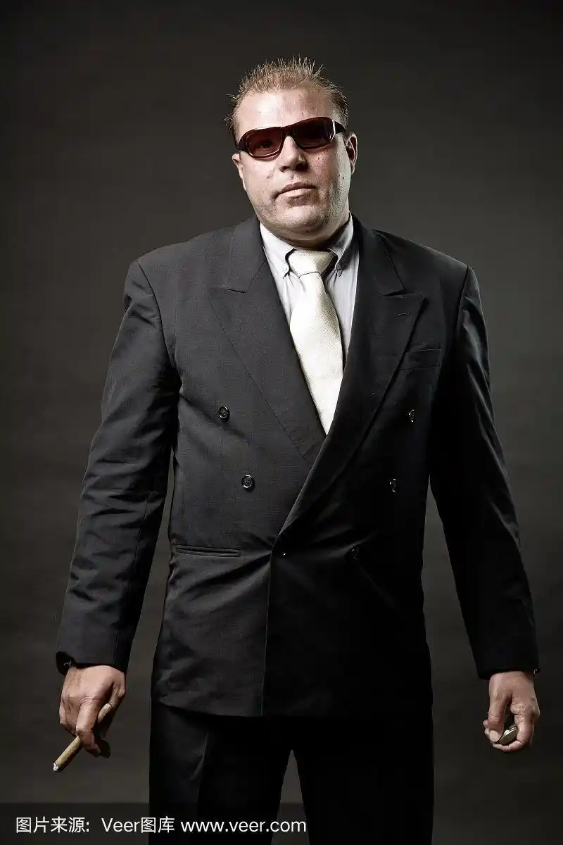 穿着西装,戴着墨镜,抽着雪茄的黑帮成员.