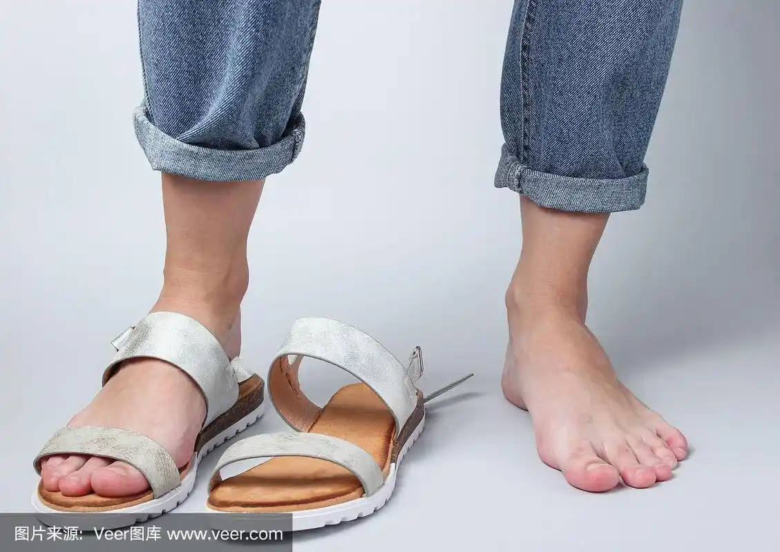 光脚的女性腿和鞋在白色的背景凉鞋