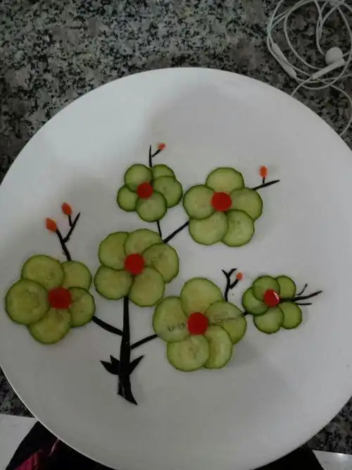 由黄瓜皮,黄瓜片,葫萝卜拼成的梅花形图案.
