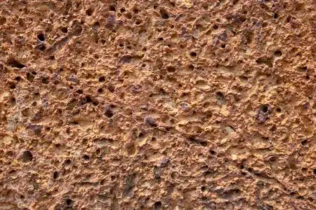 粗糙的沙石纹理.多孔橘石特写.风化粗糙的表面照片背景.