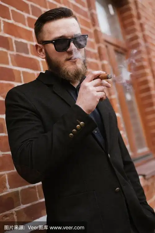 英俊的蓄着胡子的男人正在抽烟