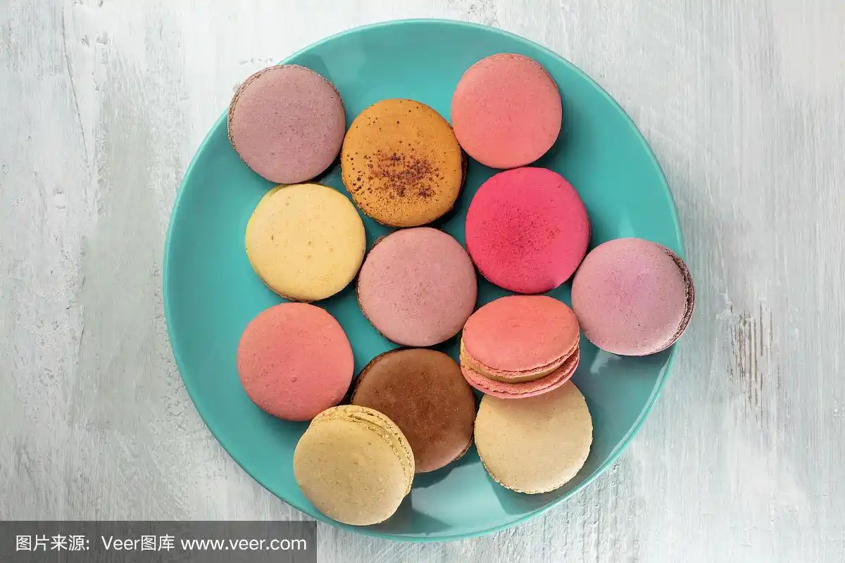 图片的马卡龙在蓝绿色的盘子与copyspace