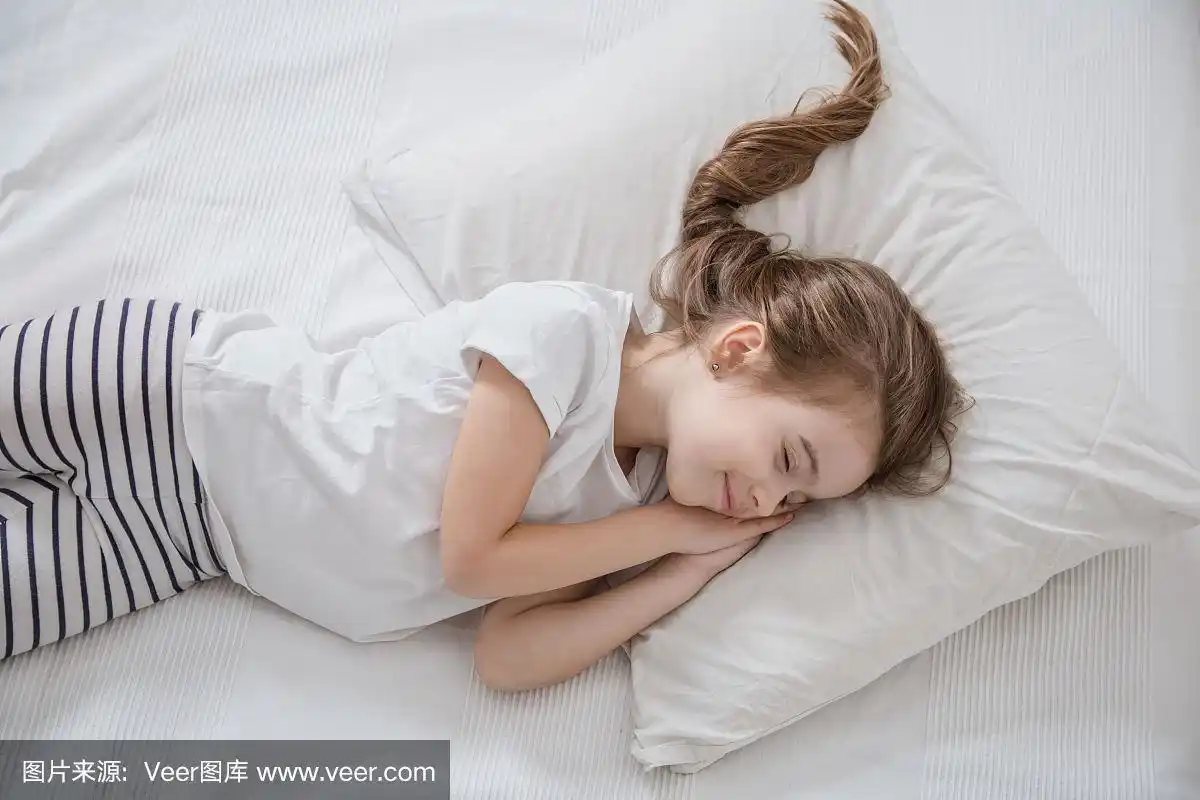 可爱的长头发小女孩睡在床上.