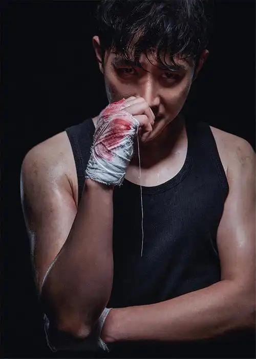 普通黑背心,手缠染血绷带,脸上及身上布满血迹和汗水,显得男人味十足