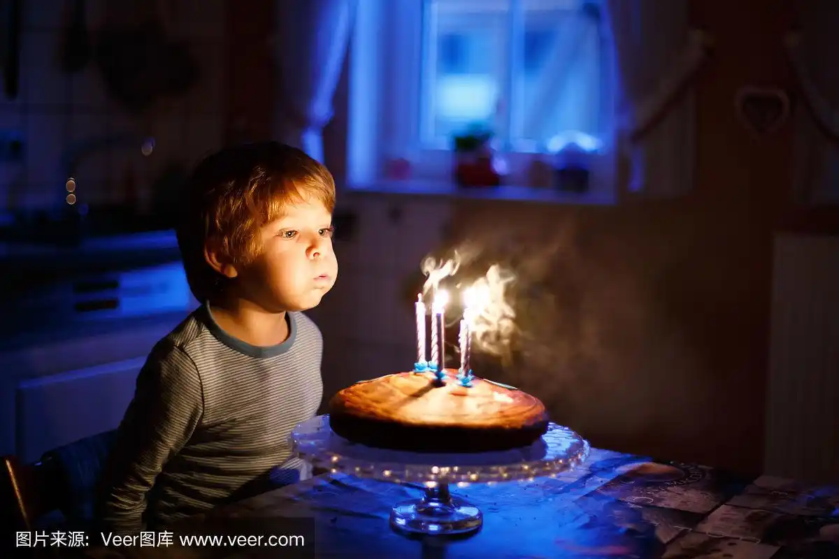 小男孩庆祝他的生日,吹蜡烛在家里