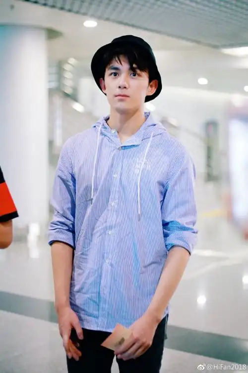 吴磊穿蓝色条纹衬衫搭配破洞牛仔裤现身机场,笑容灿烂帅气十足!