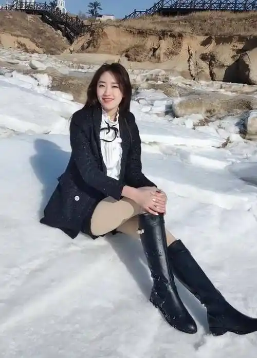 雪景中的时尚美女穿长靴热裤映衬反季魅力