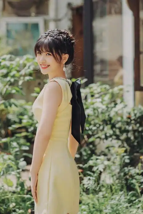 赖美云身穿一袭黄色连衣裙,搭配白色高跟鞋,翡翠项链点缀优雅