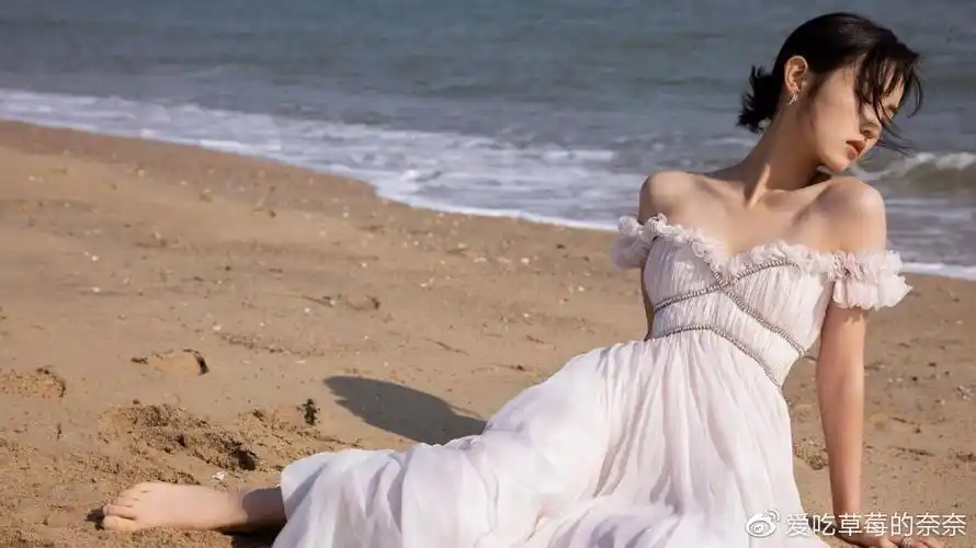 张子枫光脚躺沙滩上拍照穿短上衣露一截细腰怕冷裹绿色大衣