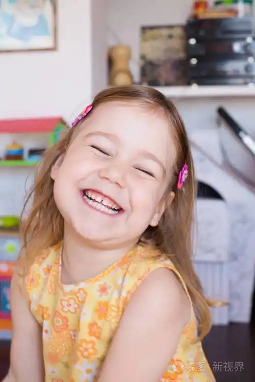 小女孩用黄色的连衣裙笑