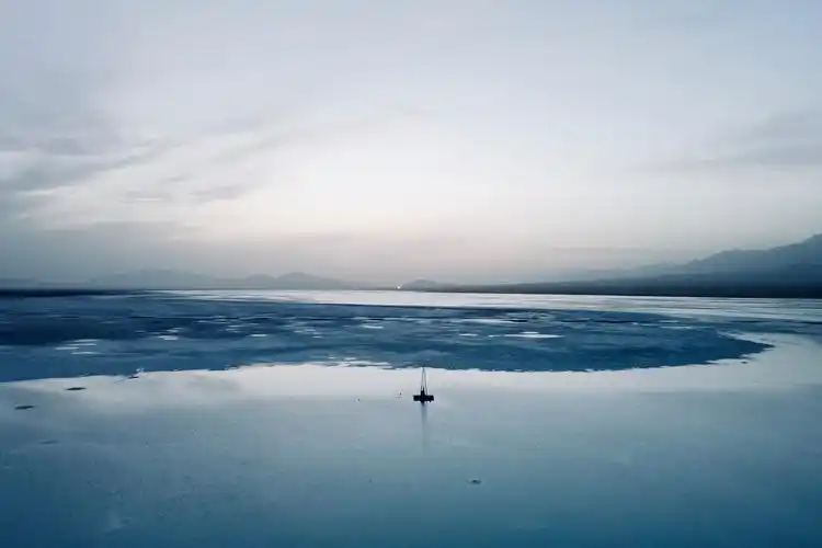 蓝色的冰湖和盐晶,远处淡色的落日 - shot by dji mavic air 2