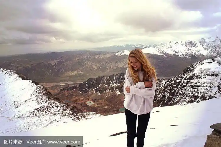 年轻的金发白种人微笑的女人在玻利维亚的山上被冻住了