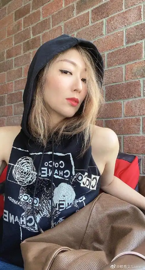 照片中的郑秀文身穿黑色连帽无袖背心,潮酷十足.