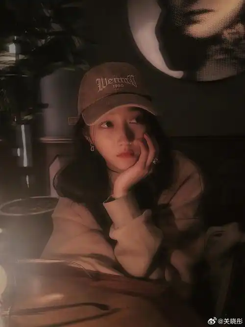关晓彤戴棒球帽穿卫衣 灯光下托腮发呆表情好萌