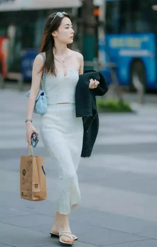 女人街拍一字肩短款上衣加长裙的针织面料套装精致时尚彰显优雅气质