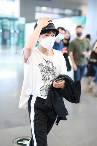 周深穿白色短t现身机场 戴渔夫帽顺毛平刘海显乖巧