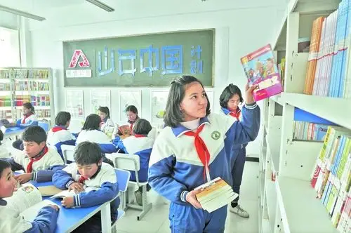 12月6日,叶城县伯西热克乡东方希望小学学生在阅览室挑选自己喜爱的