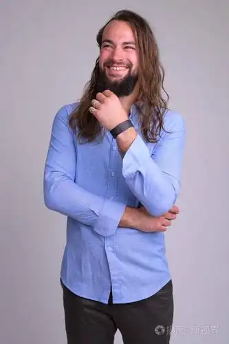 摄影棚拍摄的留胡子的年轻英俊男子长发在白色背景下