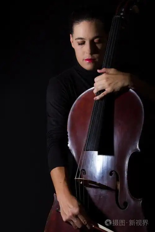 美丽的黑发控股大提琴与选择性光黑色 d照片-正版商用图片1fw4o1-摄图
