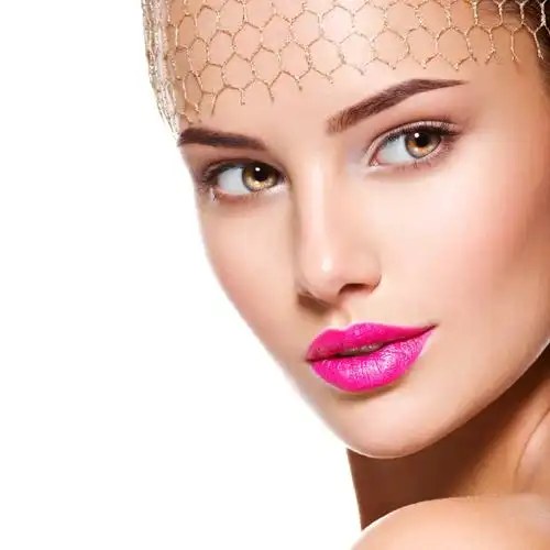 白色背景下精致妆容的美女戴着金色面纱