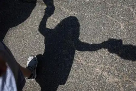 一个有孩子牵手的家庭的影子照片