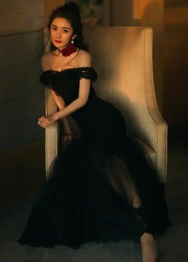 杨幂黑色鱼尾裙,化身为暗夜黑天鹅,颈上鲜红玫瑰花做装饰,明媚妖娆
