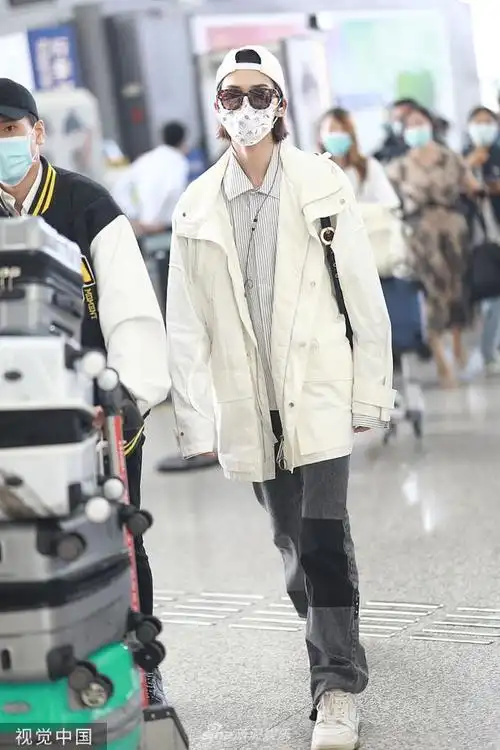 组图:朱正廷反戴棒球帽潮范儿足 低头看手机模样呆萌