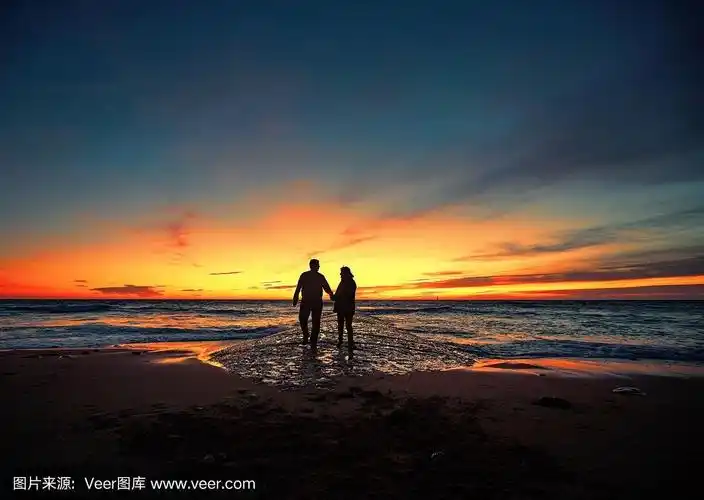 一对老年情侣在夕阳下在海边跳舞