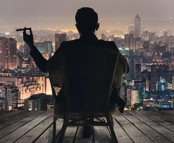 坐在椅子上的抽烟的商人的剪影