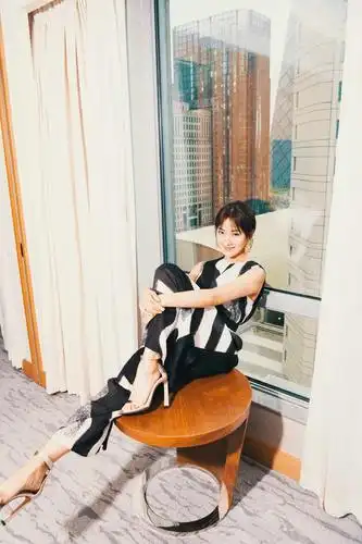 照片中菅纫姿梳着低马尾,身穿黑白不规则花纹连体裤,脚踩香槟色高跟鞋