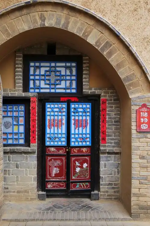 土窑配上木门木窗,门上贴着对联,窗花,很喜庆.