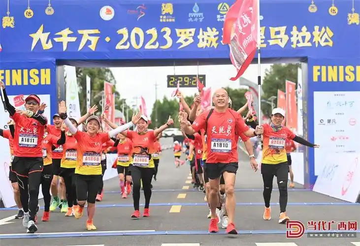 在广西罗城仫佬族自治县城东工业园区,半程马拉松赛选手冲过终点