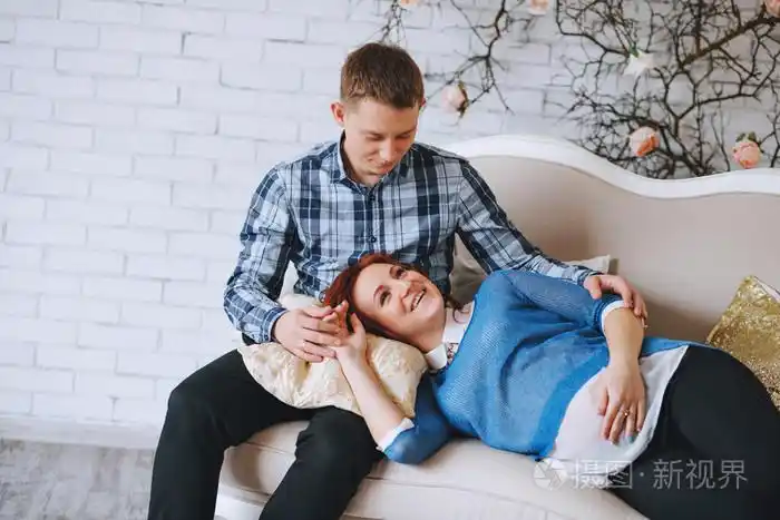 女人躺着的男子的膝盖.丈夫拥抱他的妻子.与颜色的玫瑰石英和天空蓝